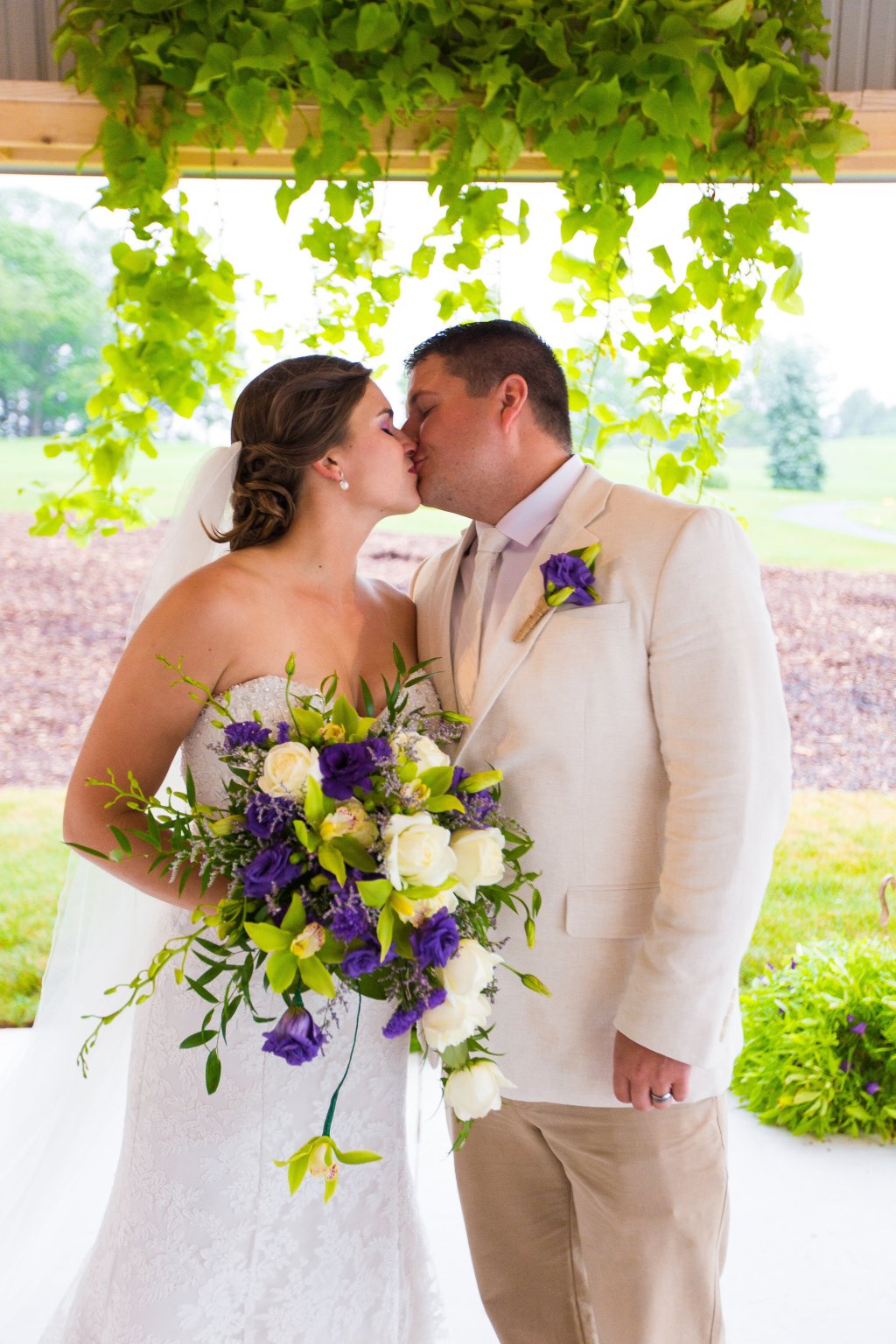 Bride and groom kissing on golf course